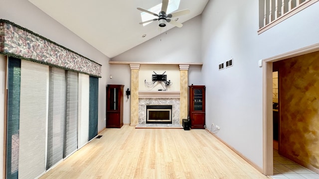 unfurnished living room featuring high vaulted ceiling, wood-type flooring, a fireplace, and ceiling fan