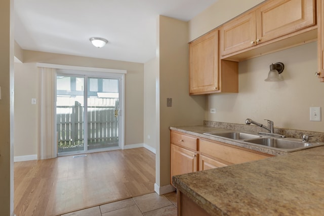 kitchen with light hardwood / wood-style flooring, sink, and light brown cabinets