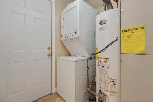 clothes washing area featuring gas water heater, stacked washer and dryer, and light tile patterned floors