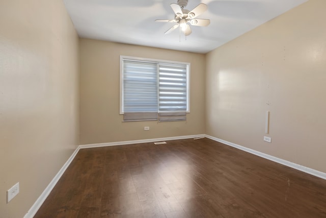 spare room featuring dark wood-type flooring and ceiling fan