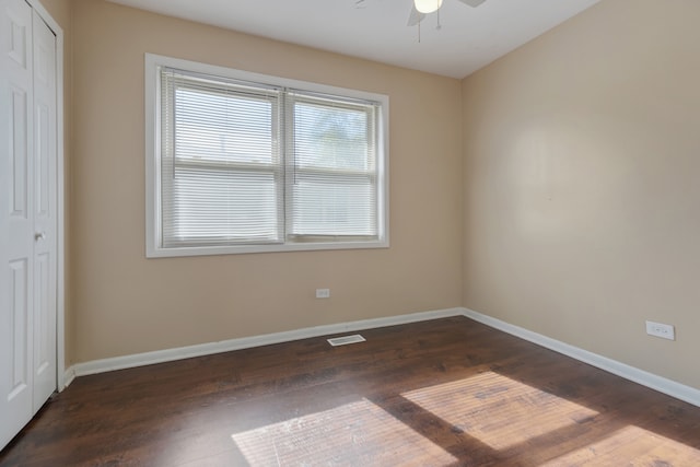 empty room featuring ceiling fan and dark hardwood / wood-style flooring