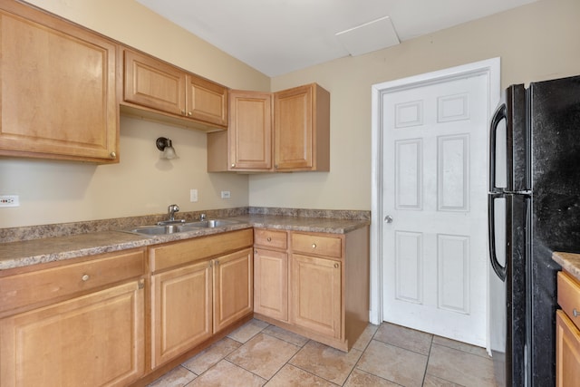 kitchen featuring light tile patterned flooring, light brown cabinets, sink, and black fridge