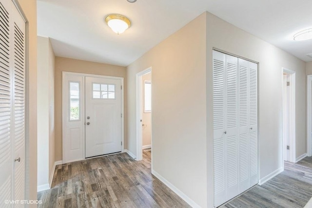 entryway featuring baseboards and wood finished floors