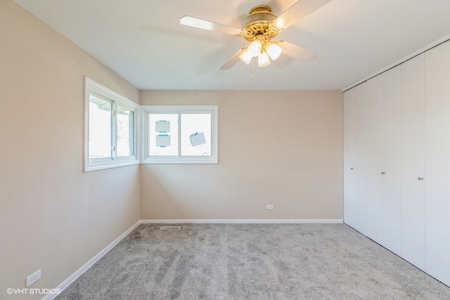 carpeted spare room featuring ceiling fan