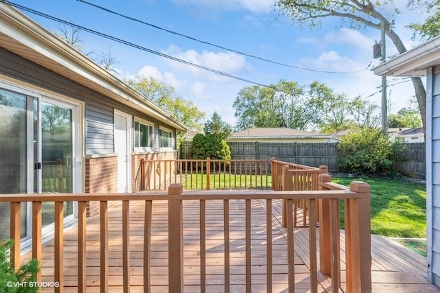 wooden deck with a fenced backyard and a yard