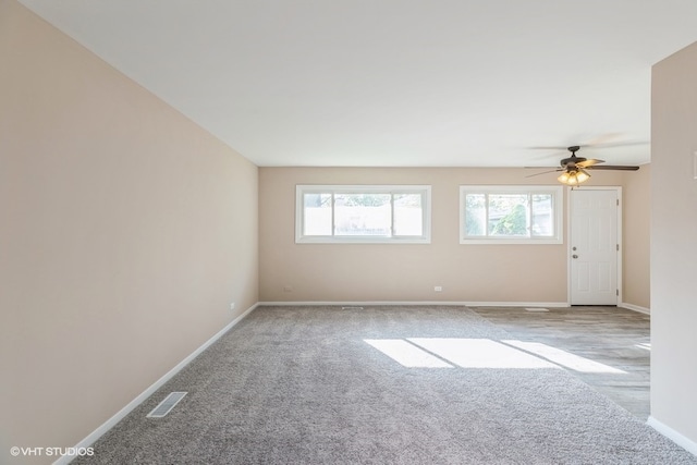 unfurnished room featuring ceiling fan, carpet, and a wealth of natural light