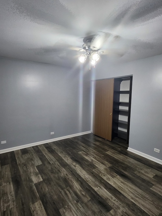 unfurnished room with ceiling fan, a textured ceiling, and dark hardwood / wood-style floors