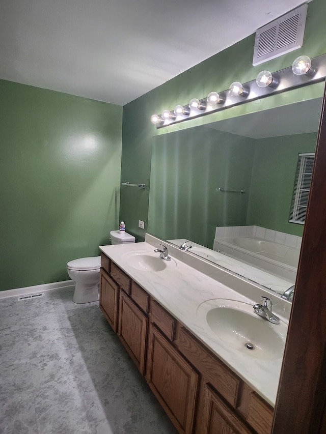 bathroom featuring vanity, toilet, and a tub