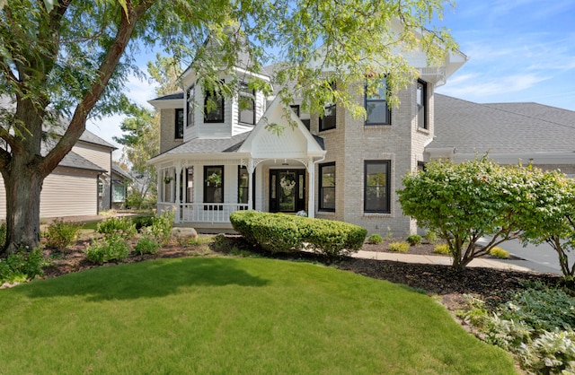 view of front of house featuring covered porch and a front lawn