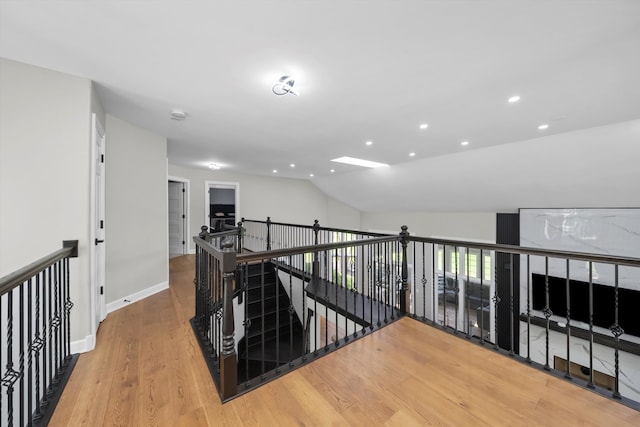 hallway with lofted ceiling and wood-type flooring