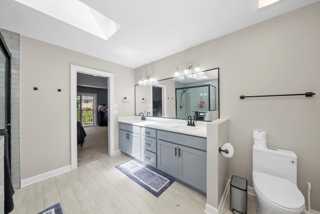 bathroom featuring walk in shower, wood-type flooring, toilet, a skylight, and vanity