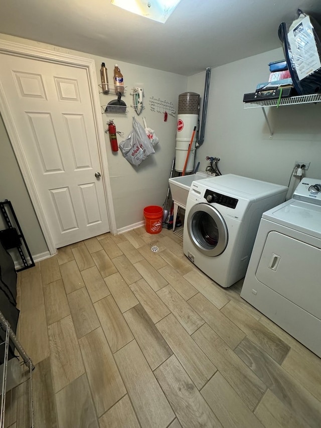 washroom with washing machine and dryer and light wood-type flooring