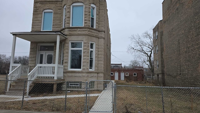 view of front of property with stone siding and a fenced front yard