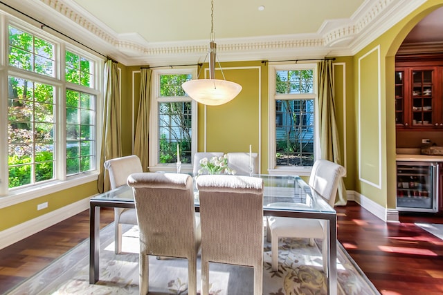 dining space with crown molding, wood-type flooring, and beverage cooler