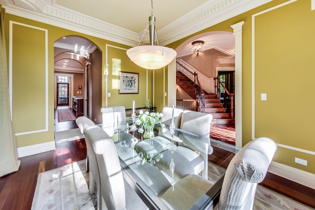 dining space with crown molding, dark hardwood / wood-style floors, and a chandelier