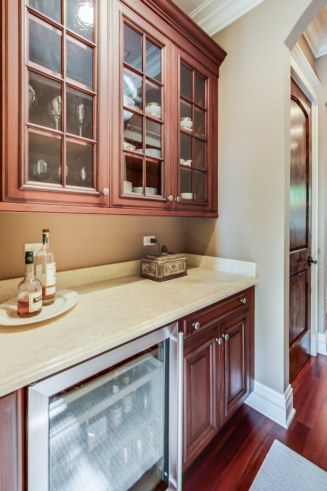 bar featuring ornamental molding, wine cooler, and dark wood-type flooring