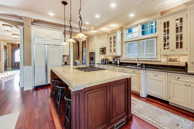 kitchen featuring dark hardwood / wood-style flooring, a breakfast bar, decorative light fixtures, and backsplash