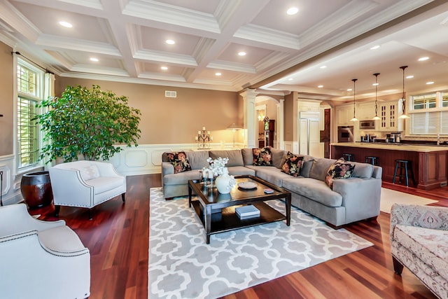 living room with crown molding, hardwood / wood-style floors, beamed ceiling, and ornate columns