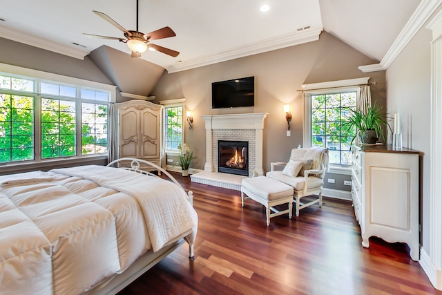 bedroom with lofted ceiling, ceiling fan, a brick fireplace, ornamental molding, and dark hardwood / wood-style floors