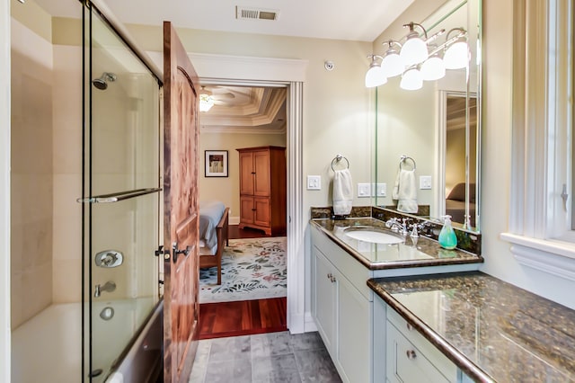 bathroom with vanity, ornamental molding, enclosed tub / shower combo, and hardwood / wood-style flooring