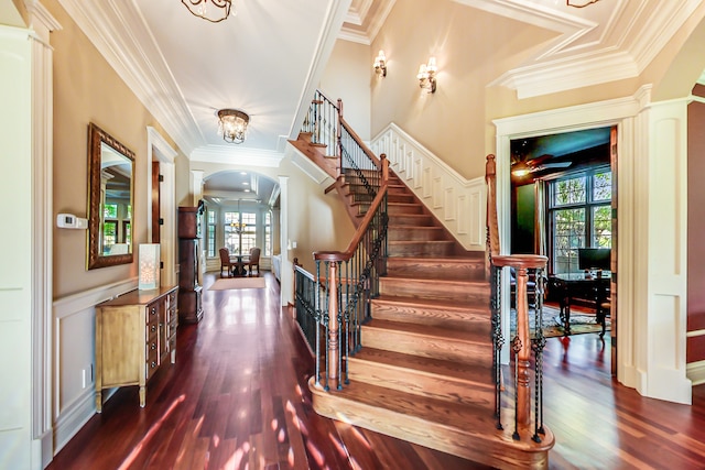 stairs featuring hardwood / wood-style floors, crown molding, and a healthy amount of sunlight