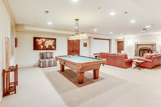 recreation room featuring pool table, crown molding, a brick fireplace, and light carpet