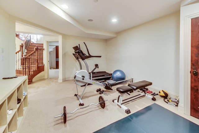 workout room featuring light carpet