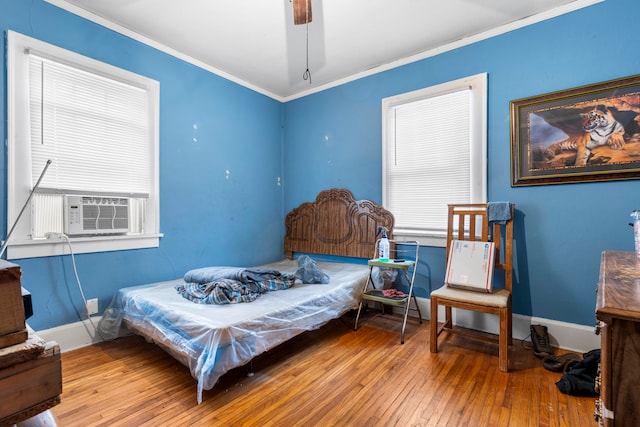 bedroom featuring ceiling fan, crown molding, wood-type flooring, and cooling unit