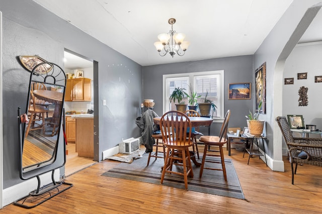 dining room with a notable chandelier and light wood-type flooring