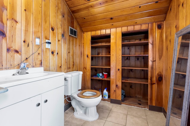 bathroom with wooden ceiling, toilet, vanity, wooden walls, and tile patterned flooring