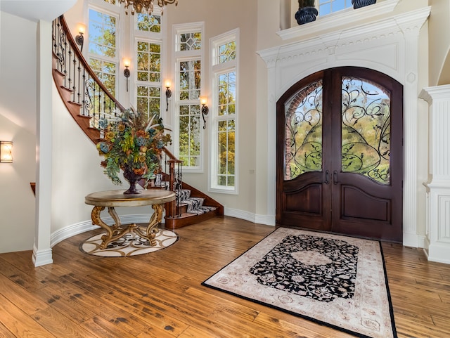 foyer entrance with french doors, hardwood / wood-style flooring, and a wealth of natural light