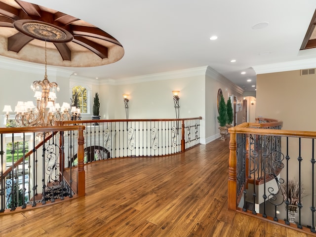 hall with ornamental molding, a notable chandelier, and wood-type flooring