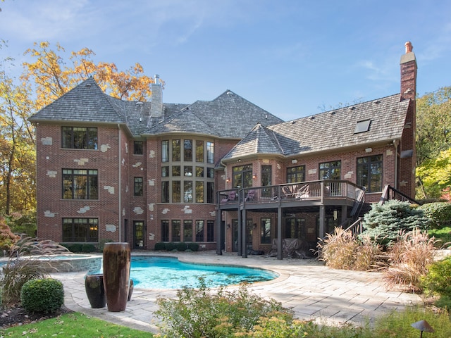 back of property featuring a patio area and a swimming pool side deck