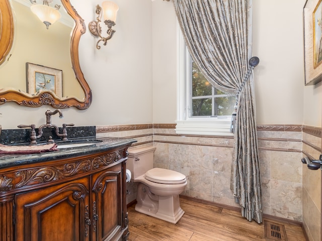 bathroom featuring vanity, toilet, tile walls, and hardwood / wood-style floors