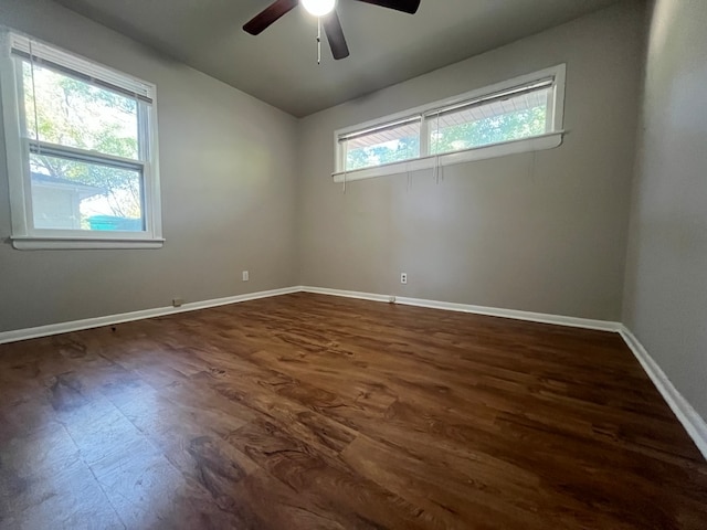 empty room featuring dark wood-type flooring and ceiling fan