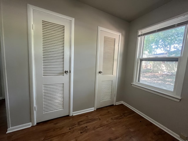 unfurnished bedroom with dark hardwood / wood-style floors