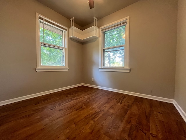 unfurnished room featuring a wealth of natural light, dark hardwood / wood-style floors, and ceiling fan