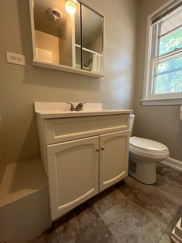 bathroom featuring vanity, curtained shower, and toilet