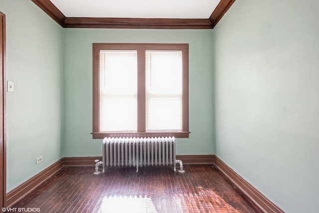 unfurnished room with crown molding, radiator, and dark hardwood / wood-style flooring