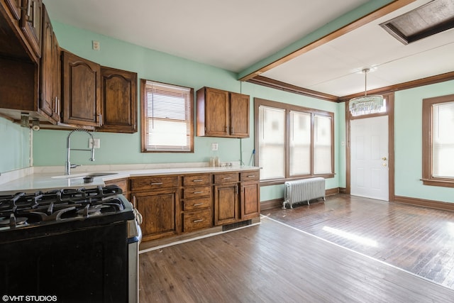 kitchen featuring radiator heating unit, hanging light fixtures, dark wood-type flooring, and a healthy amount of sunlight