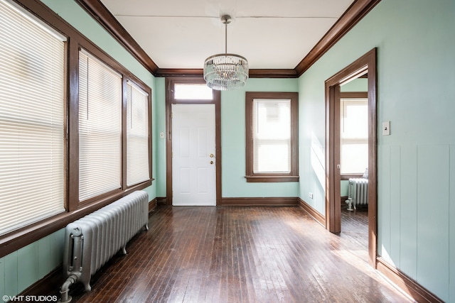 interior space with a notable chandelier and radiator heating unit