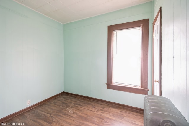 empty room featuring dark wood-type flooring and wood walls