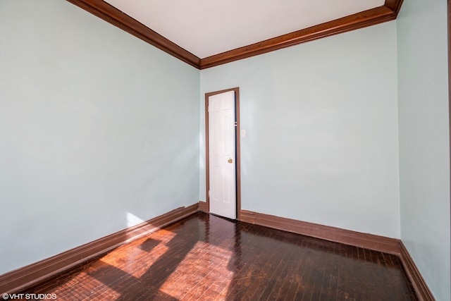 empty room featuring hardwood / wood-style flooring and ornamental molding