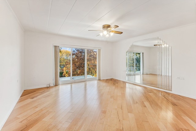 empty room featuring light hardwood / wood-style flooring, ceiling fan with notable chandelier, and crown molding