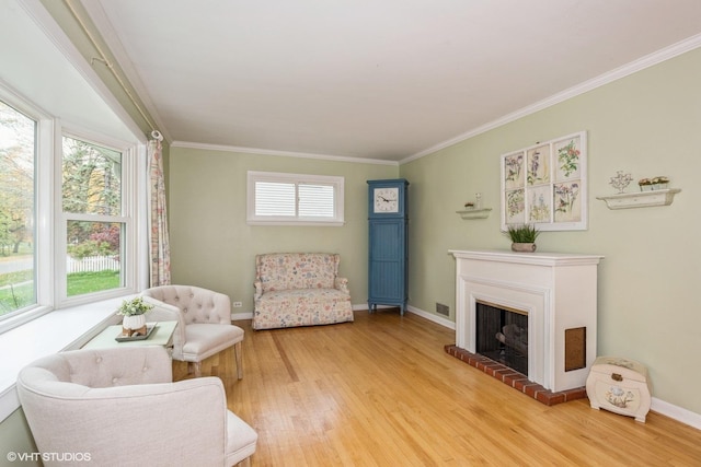 sitting room featuring crown molding, a fireplace, and hardwood / wood-style floors