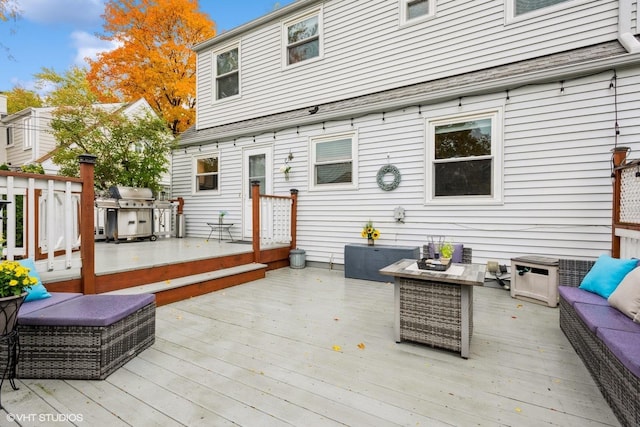 wooden terrace with a grill and outdoor lounge area