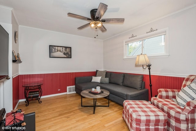 living room with wood-type flooring, ceiling fan, and crown molding