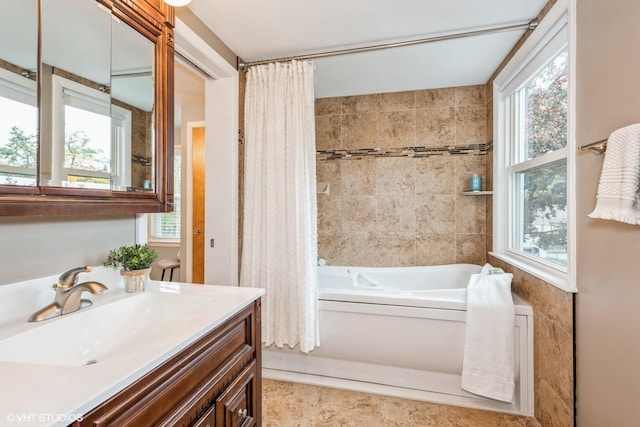 bathroom with vanity, a bathing tub, and a wealth of natural light