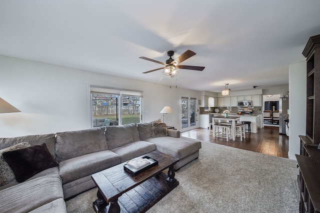 living room with dark hardwood / wood-style floors and ceiling fan