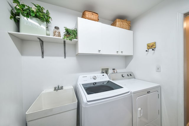 laundry room with washer and clothes dryer, cabinets, and sink